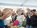 Vecinos celebrando en la carpa gastronómica