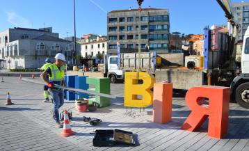 Operarios retirando el corazón en los letreros de Ribeira