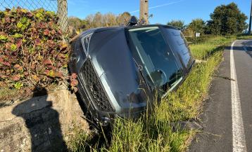 Un coche se salió de la vía por el margen dertecho y acabó semivolcado y apoyado en un muero de una finca