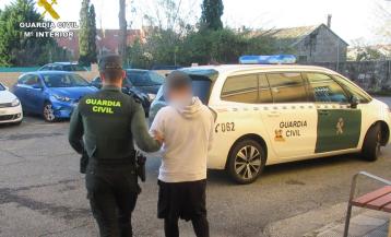 Un agente conduce al detenido