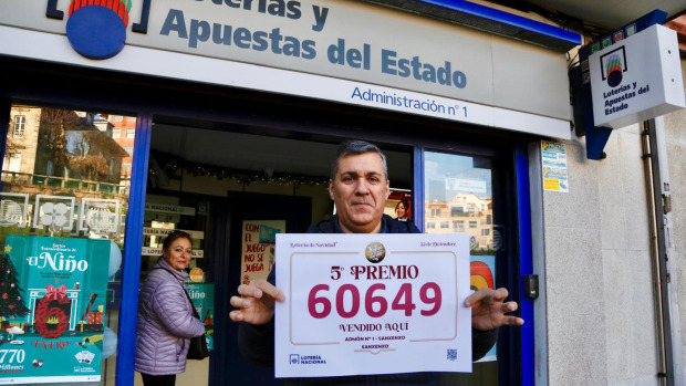El lotero portando el número que corresponde al Quinto premio