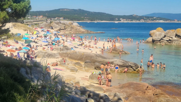 Vecinos y turistas en una playa de O Grove