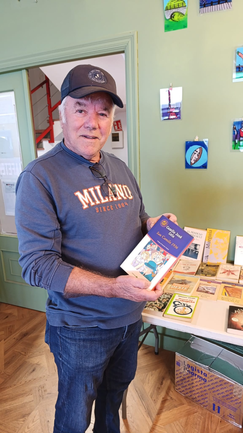 Un cliente de la cafetería de O Grove con uno de los libros que regalan