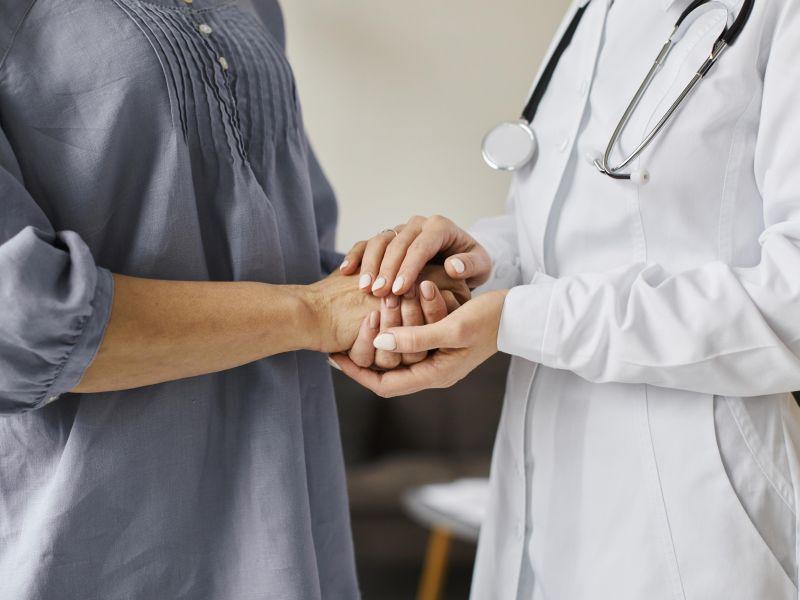 Centro de recuperacion de covid doctora sosteniendo las manos del paciente mayor