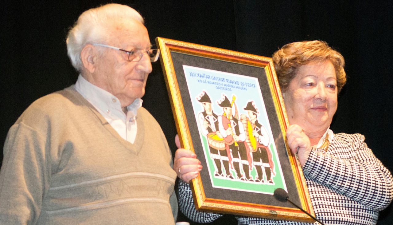 Xosé Romero y Maruxa Miguéns exhibieron en marzo de 2017 el cuadro conmemorativo con que les obsequió el entonces alcalde rianxeiro, Adolfo Muiños, en el XXII Xantar Gaiteiro de la AGG