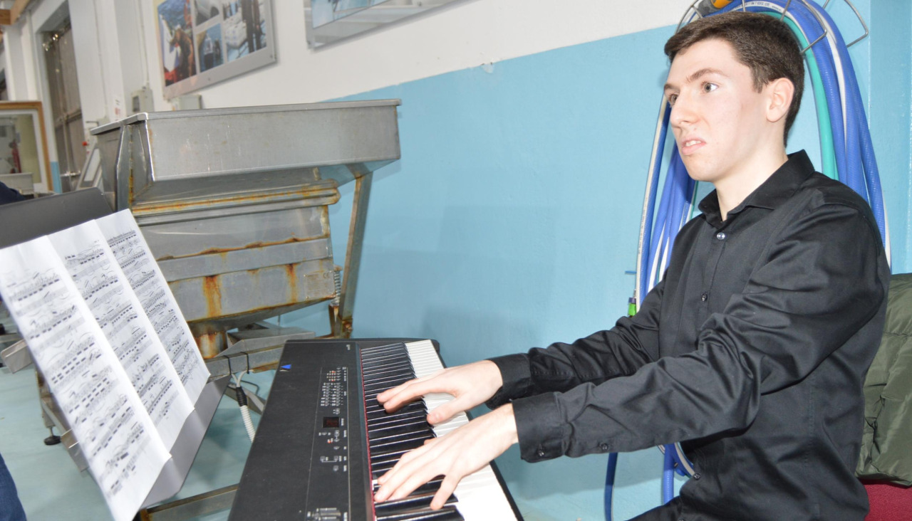 El joven ribeirense Miguel González Maceiras realizó una intervención musical al piano durante el acto de presentación del libro de Daniel Bravo sobre el pósito de Carreira-Aguiño