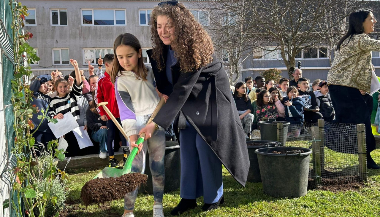 La concejala Juana Brión y una alumna del colegio Galaxia aportaron tierra durante la plantación del rosal en homenaje a Rosalía de Castro