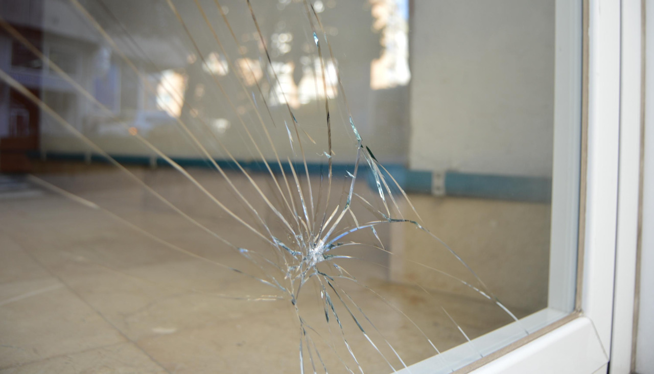 Un cristal inferior del portal de un edificio de vi viendas del tramo final de la Rúa de Galicia sufrió daños tras recibir una patada