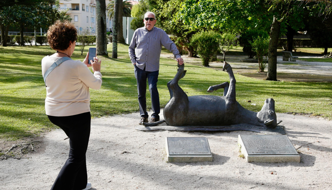Turistas posando con la escultura del burro de A Toxa