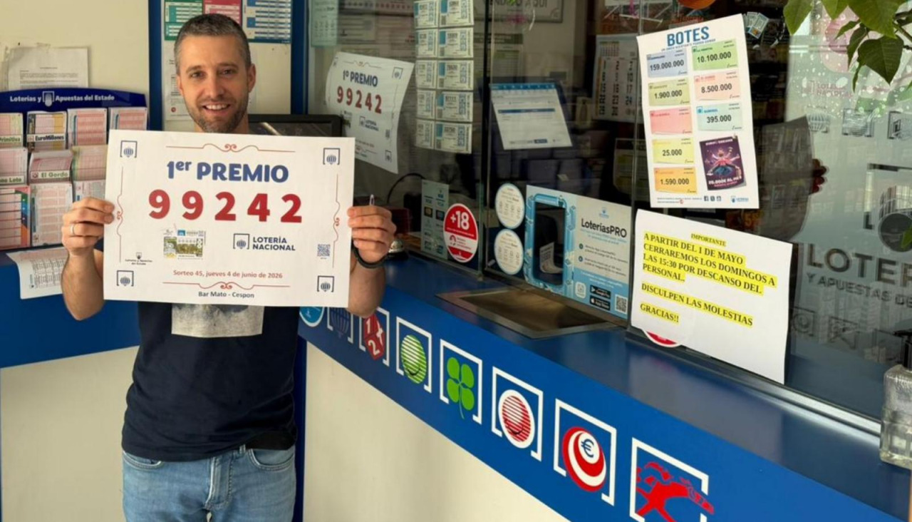 Valentín Mato muestra el cartel con el número agraciado en el sorteo de la Lotería Nacional del jueves y del que vendió un décimo