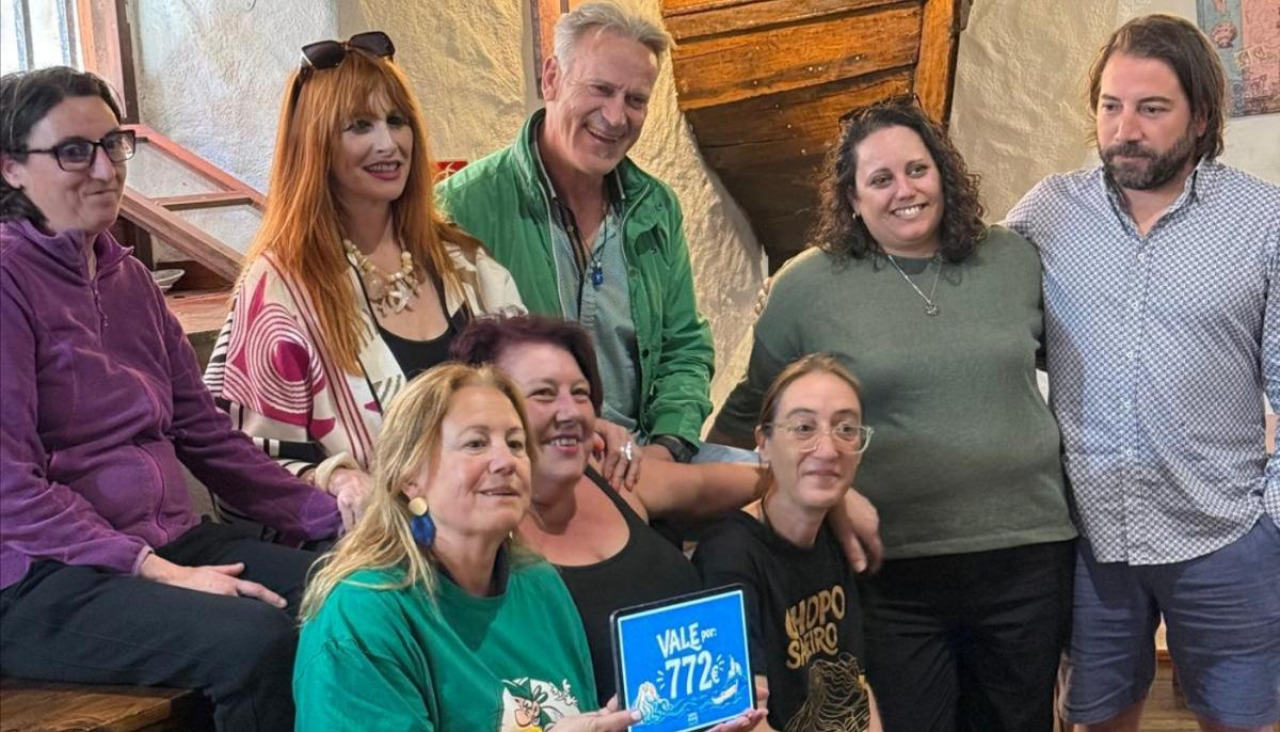 Gloria Abalo, vocal de la Asociación Galega de Afectados de Esclerosis Lateral  Amiotrófica, muestra el importe de la donación recibida