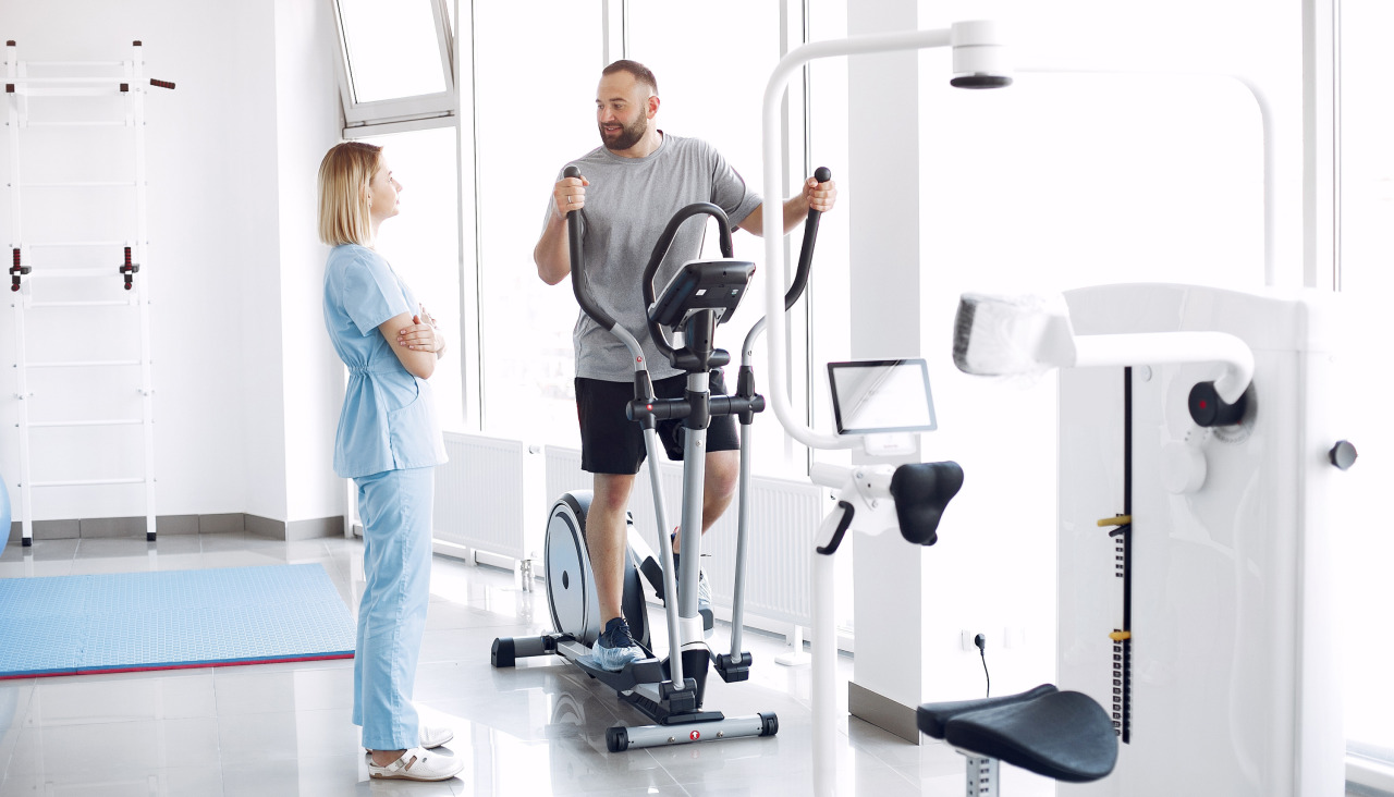 Paciente haciendo ejercicio en bicicleta de spinning en el gimnasio con el terapeuta