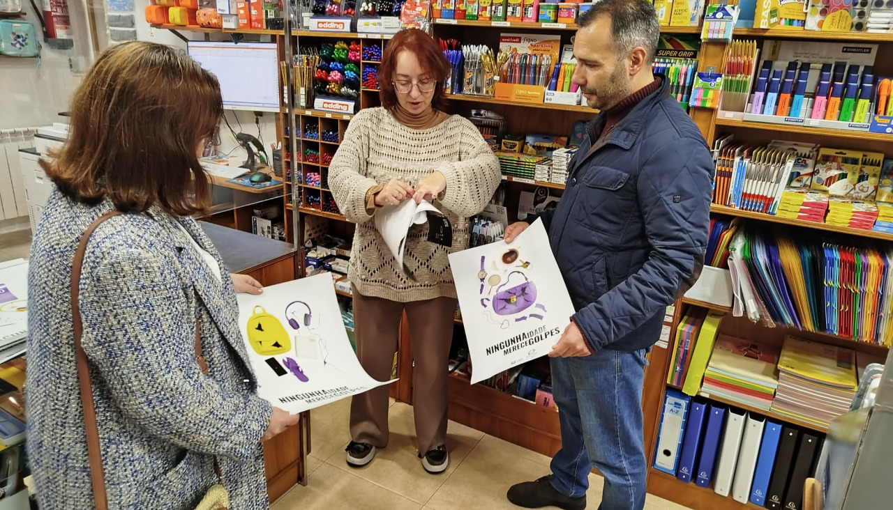 El alcalde de Caldas repartiendo los carteles de la campaña del 25-N entre los comercios locales