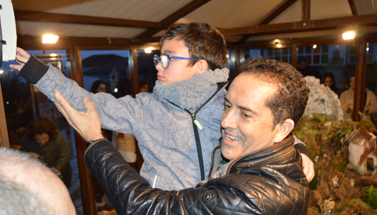 Abián García, de 8 años, con la ayuda de Miguel Abraldes, fue el encargado de pulsar el botón de encendido del belén mecánico de Aguiño