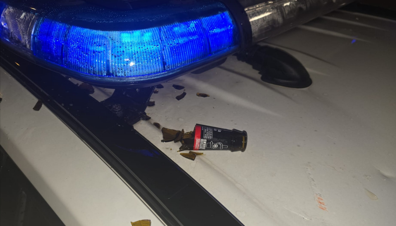 El individuo arrestado causó daños en el vehículo policial contra el que arrojó una botella de vidrio en la `primera madrugada del presente año