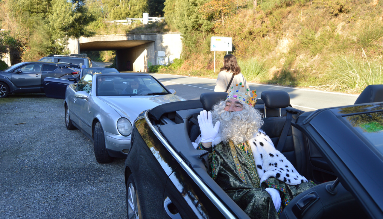 El Rey Melchor saluda a los asistentes en la salida desde el lugar de A Tomada del recorrido en coches descapotables que les llevó por las parroquias rurales pobrenses