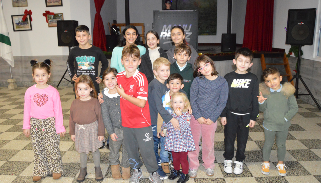 Uno de los grupos de niños asistentes a la fiesta infantil en el Centro Recreativo de Artes posaron delante del escenario de DJ Manu Reiriz