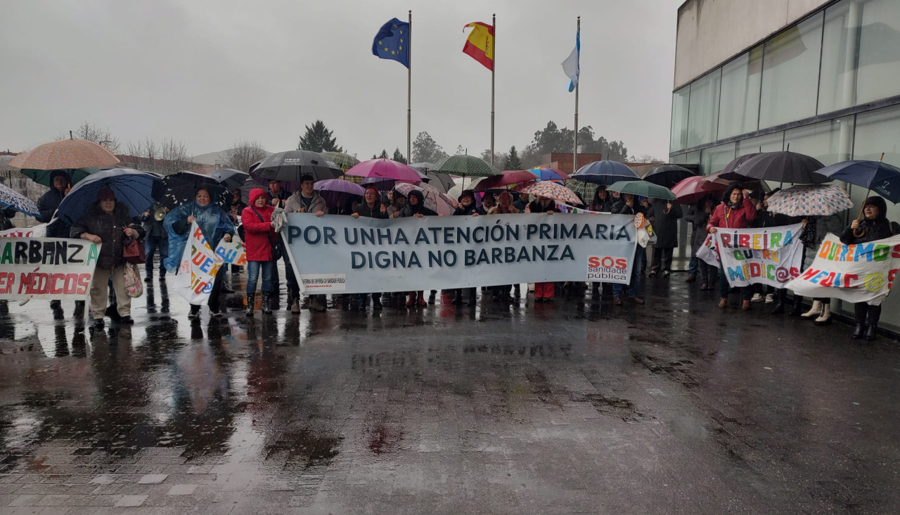 La concentración de barbanzanos ante la sede de la sede de la Consellería de Sanidade, en el barrio compostelanop de San Lázaro, se desarrolló en medip de una incesante lluvia