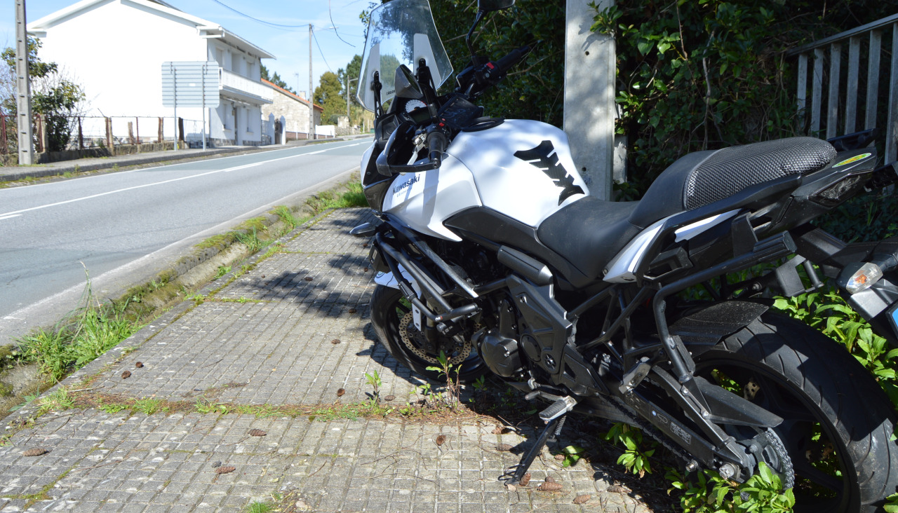 Una motocicleta Kawasaki Versys de gran cilindrada se salió de la vía, metió una rueda en una tajea y fue a parar al suelo de la calzada de la AC-302 en Xenxides