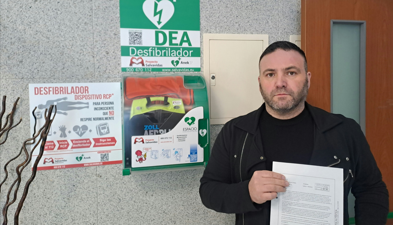Miguel Piqueras, coordinador local de UCIN Boiro, denuncia que el desfibrilador colgado de una pared del centro social de la villa está "fuera de servicio"