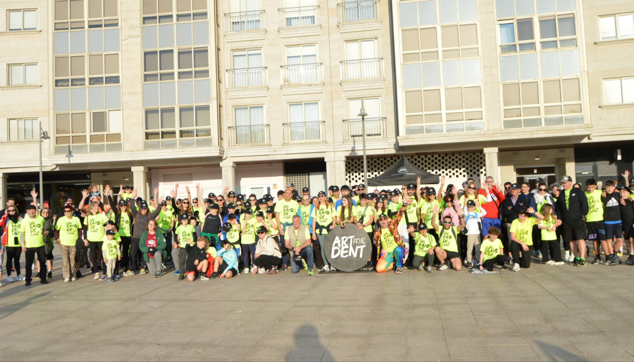 Los participantes en la caminata se hicieron la protocolaria fotografía antes de tomar la salida junto al logotipo de la asociación 'Art for Dent'