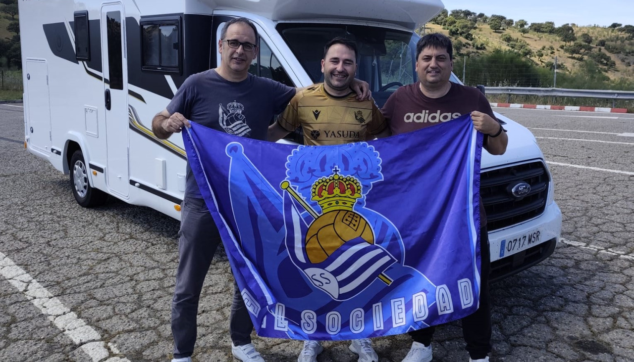 Carlos Gómez, Daniel Chaves y Jose Chantrero, posan con la bandera de la Real de camino a Sevilla