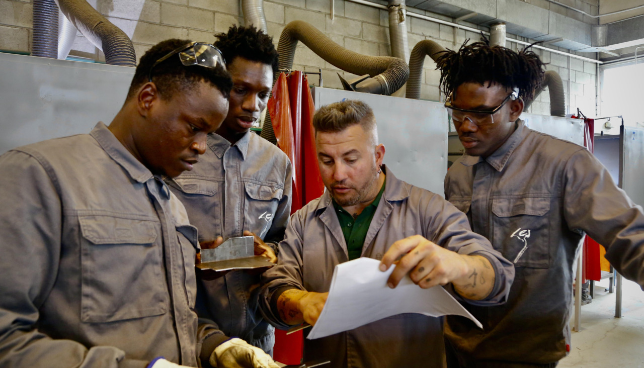 Migrantes con el profesor de la formación, Pablo Bello