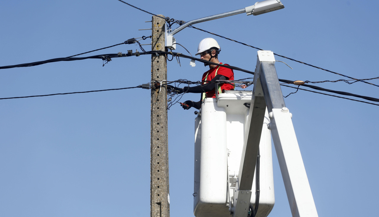 Un operario realiza operaciones en un poste de tendido