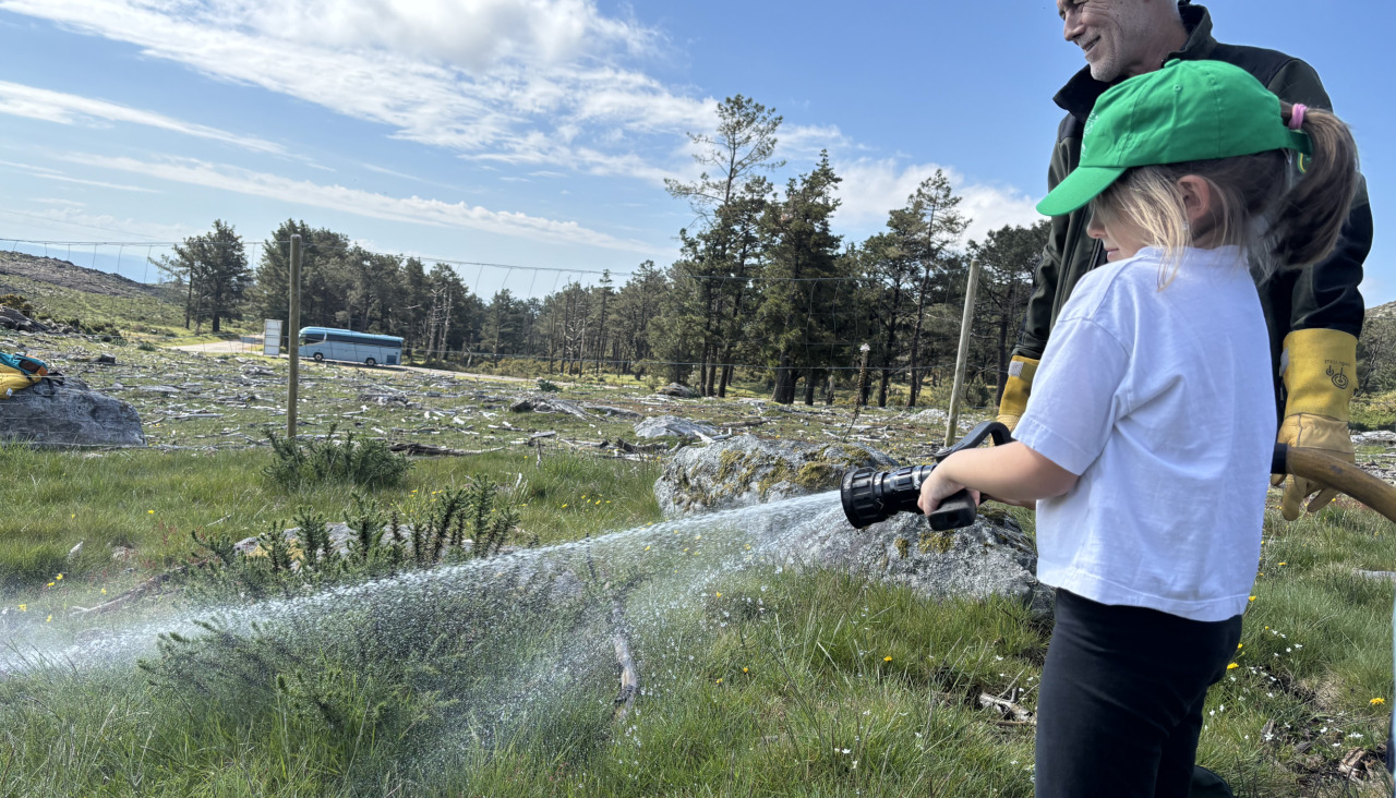 Imagen de riego por parte de un escolar de Bandaseca durante la plantación que se llevó a cabo ayer en el monte de A Curota