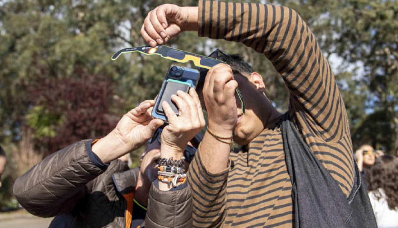 30 marzo 2025Dos personas observan un eclipse solar