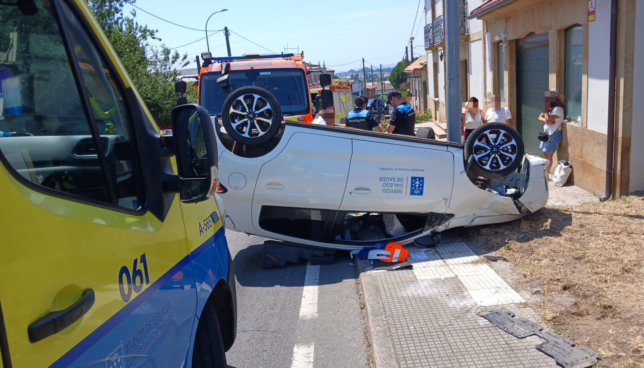 El vehículo volcado en la entrada de una vivienda