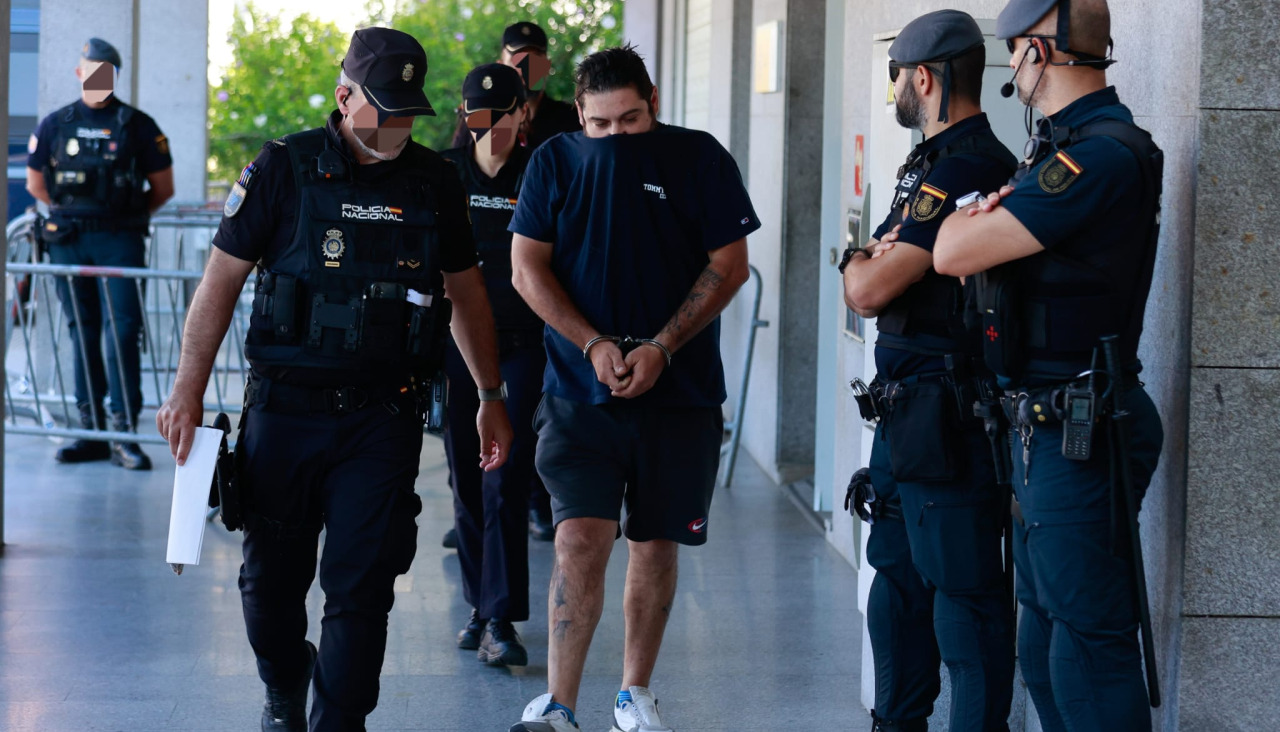 Agentes de la Policía Nacional conducen a uno de los detenidos, este jueves