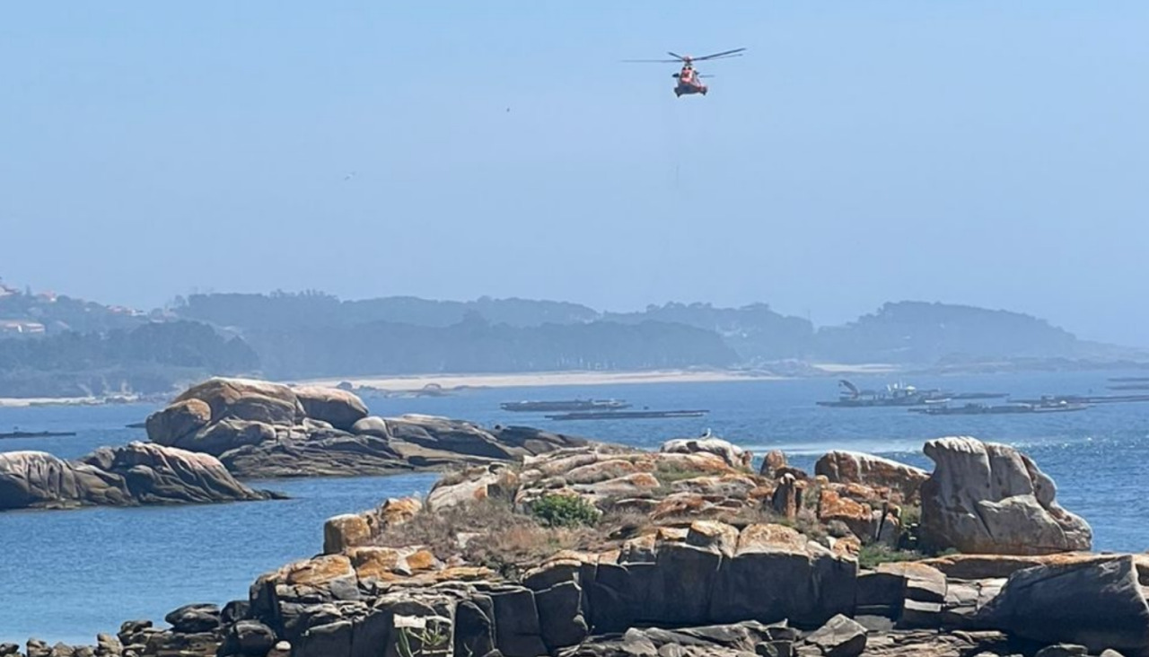 El helicóptero de Salvamento Marítimo estuvo sobrevolando la zona litoral de Insuela hasta que uno de sus tripulantes descendió para recoger a una persona en unas piedras