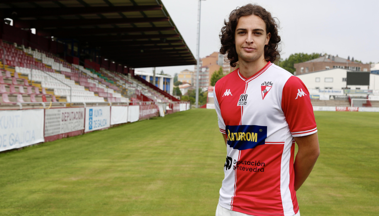 El centrocampista ferrolano Hugo García posa con la camiseta del Arosa en el campo de A Lomba, donde fue presentado ayer por el presidente Manolo Abalo como el segundo fichaje para Segunda RFEF