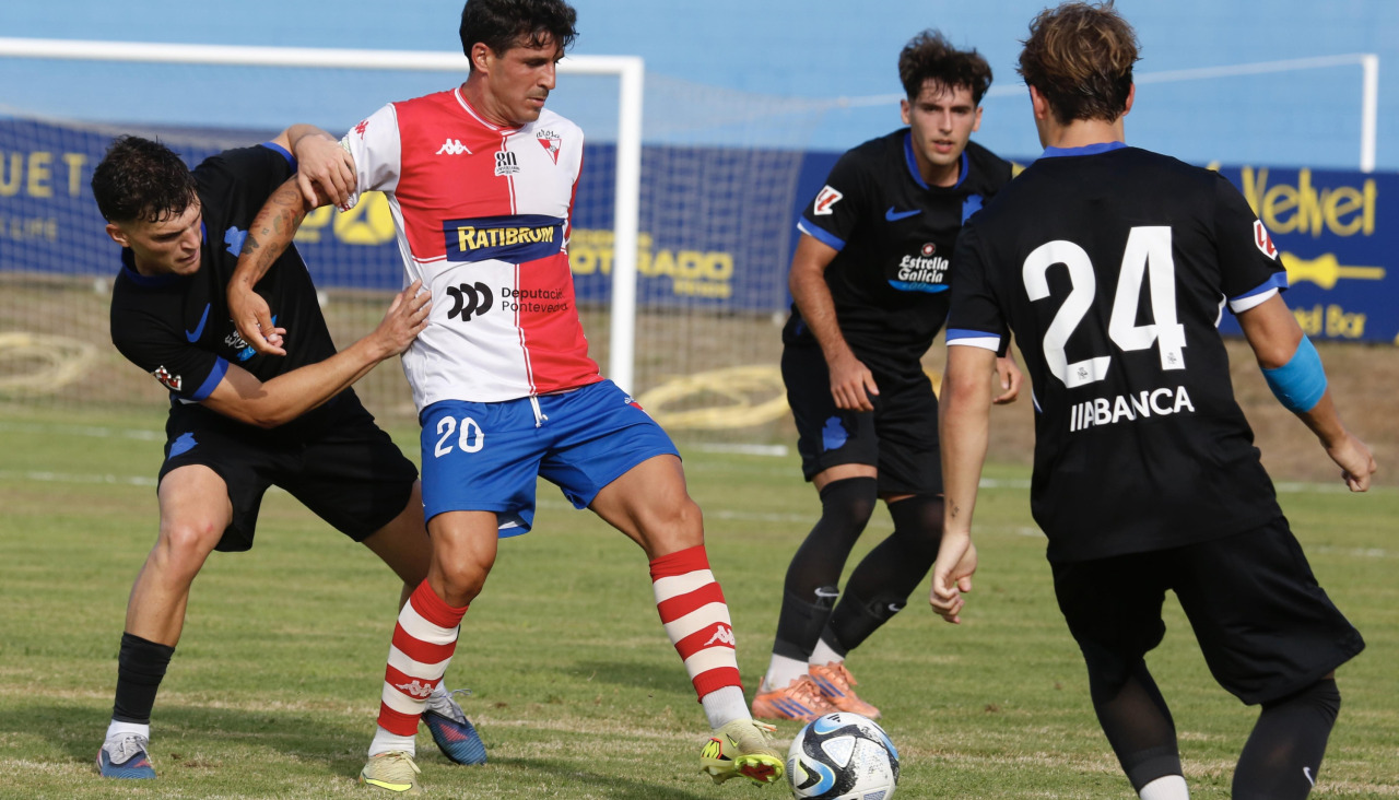 Álex Rey controla el balón rodeado de rivales