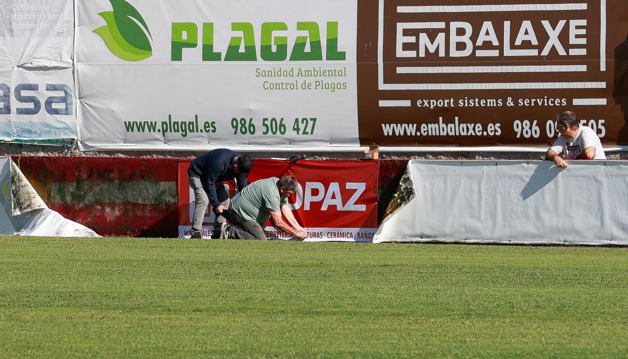 Directivos del Arosa colocan nuevas lonas publictarias en A Lomba con los colores rojo y blanco